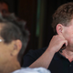 Bobby Kotick awkwardly scratches his neck at an event.